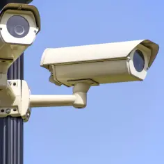 Dwie kamery monitoringu na słupie, gotowe do pracy z programem do monitoringu przez internet.