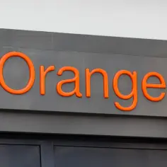 Pomarańczowy napis "Orange" na szarym tle. Może to zapowiadać darmowy internet Orange.