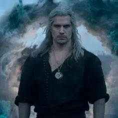 Henry Cavill, wiedzmin aktor, stoi w otoczeniu magicznej mgły.