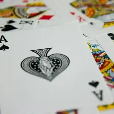 As pik w grze durak, otoczony innymi kartami, królowymi i waletami, czeka na swoją kolej.