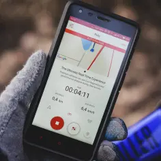 Rękawiczka trzyma smartfon z mapą i danymi przejazdu. To najlepsza darmowa aplikacja na rower, pokazująca dystans, czas i prędkość.