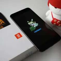 Xiaomi telefon w trybie fastboot, obok figurka Mi Bunny i pudełko.
