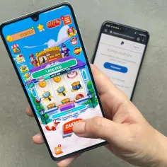 Gra Coin Master na telefonie, jedna z aplikacji do zarabiania, obok ekranu z PayPal.