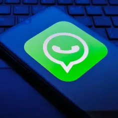 Telefon z ikoną WhatsApp na ciemnym tle klawiatury. Czyżby awaria WhatsApp?