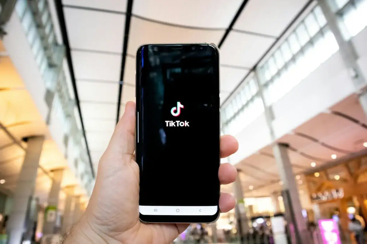 Dłoń trzyma smartfon z logo TikToka. Czyżby kolejna awaria TikToka?